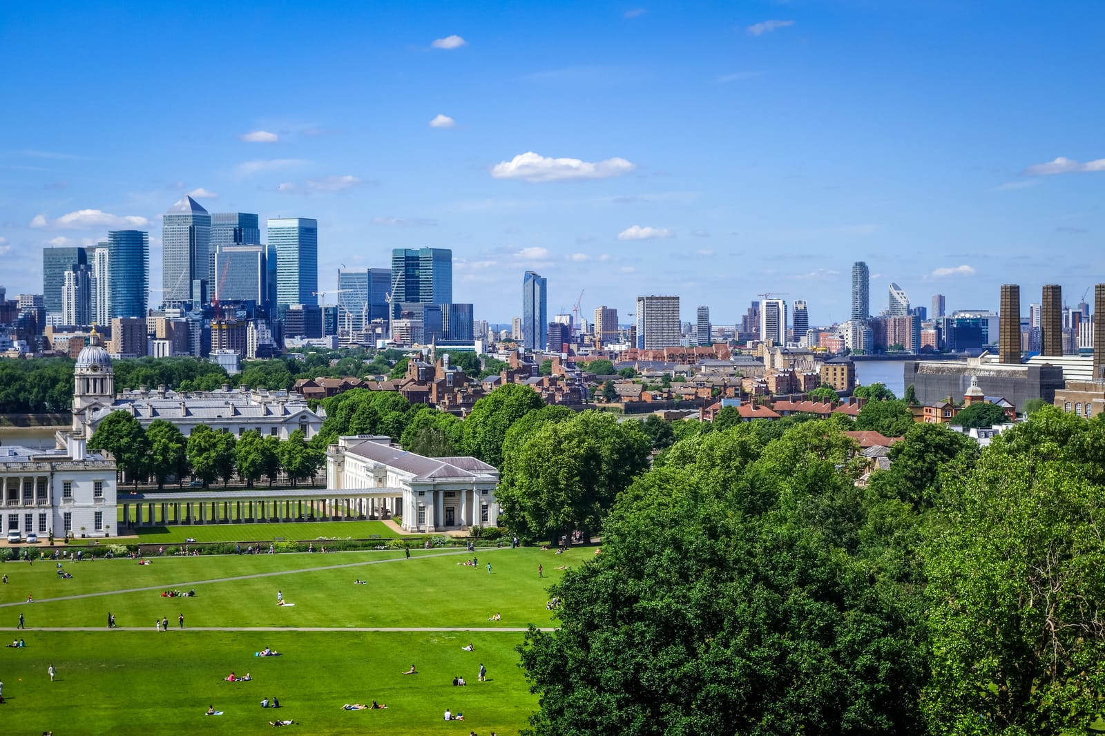 Canary Wharf towers seen from Greenwich Park, above the Queen's House and sunny lawns